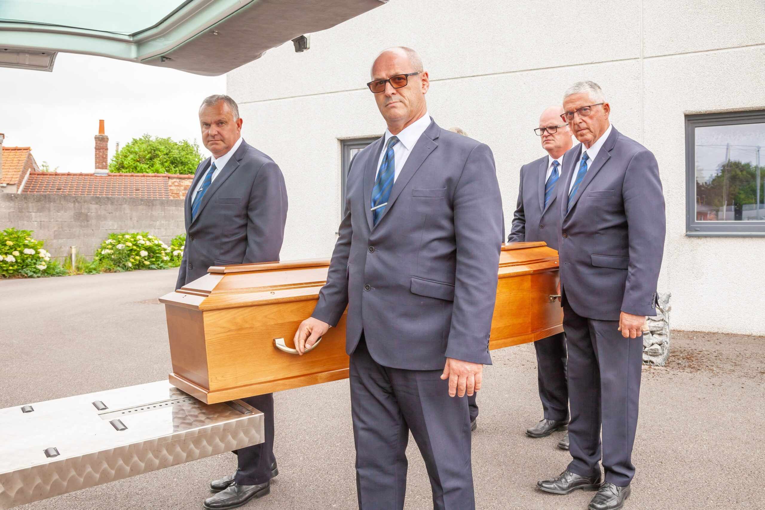 personnels funeraires portant un cercueil