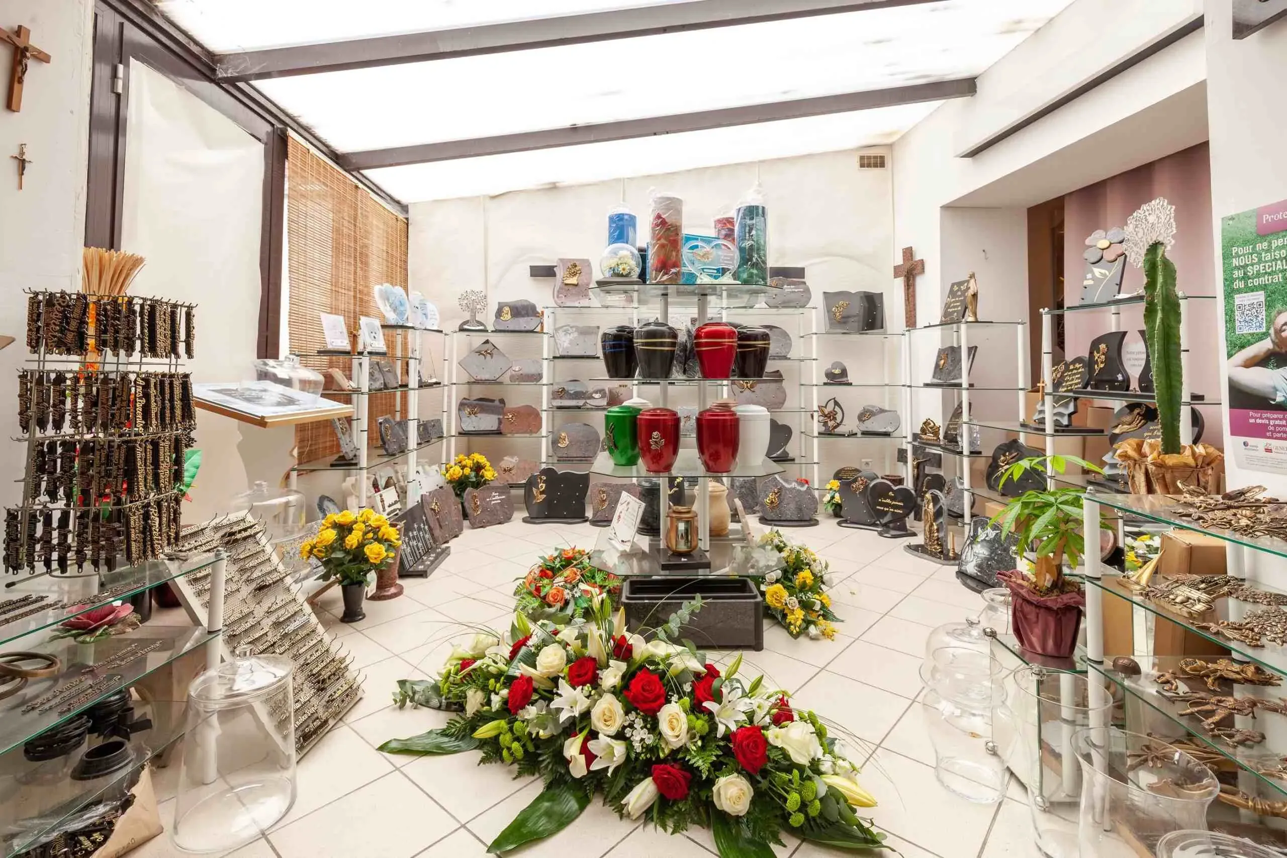 Boutique d'articles funéraires exposant urnes, plaques commémoratives et compositions florales.